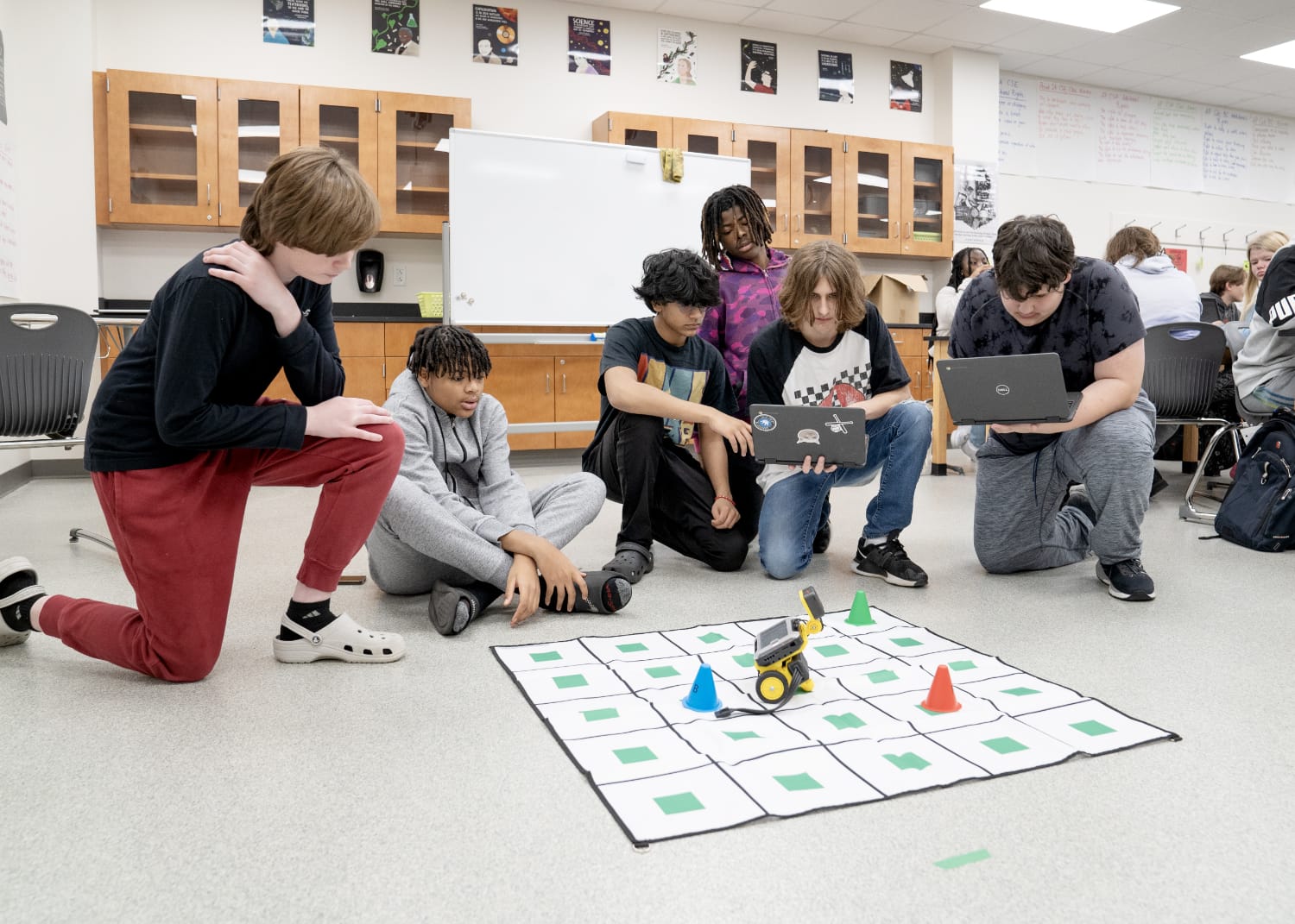 Students with a robotic game on the floor